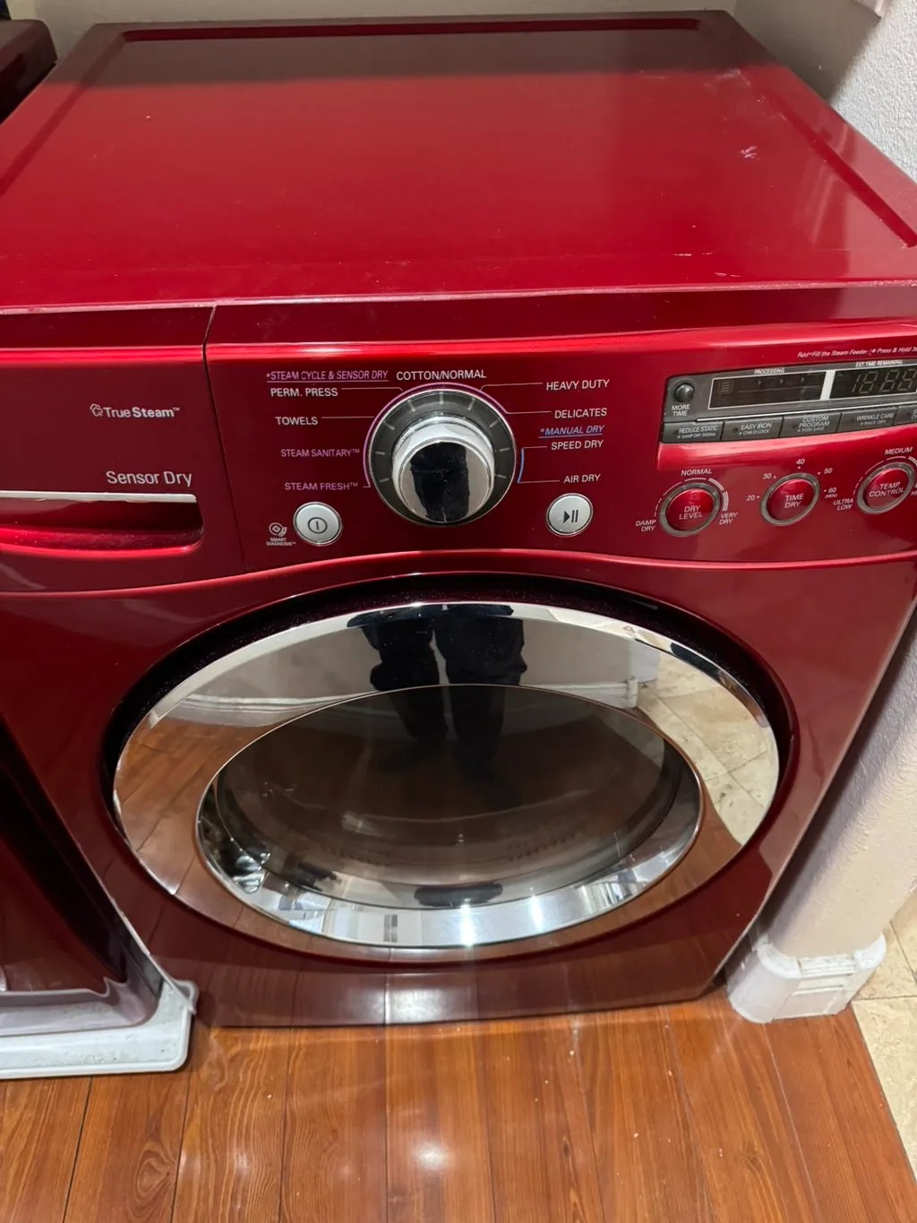 Red LG front load dryer with the control panel and drum in view