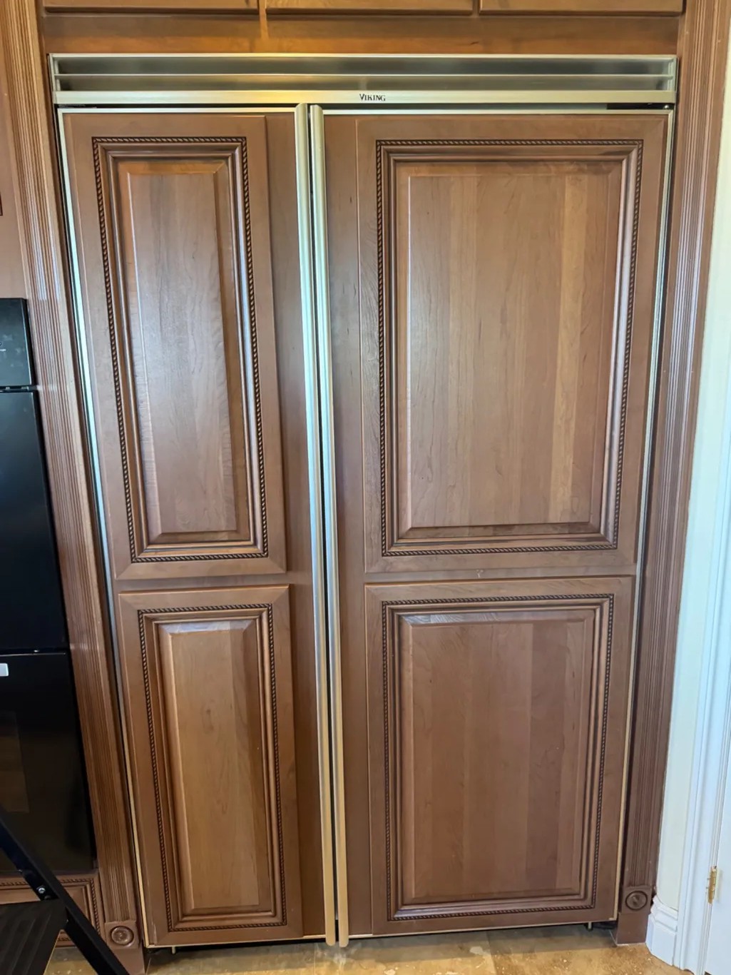 Built-in Viking refrigerator with custom wood panels, ready for repair